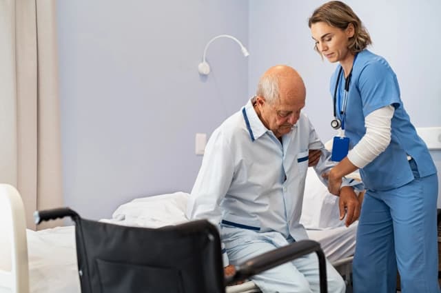 a nurse take care of an old man in a hospital